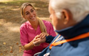 A caregiver in pink scrubs holds the hands of an elderly man wearing a blue jacket and an SOS button. Dementia retirement home concept image- Stock Photo or Stock Video of rcfotostock | RC Photo Stock