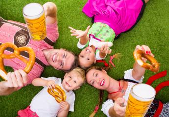 A cheerful family in traditional Bavarian attire, lying on grass, holding pretzels, beer, and sausages, celebrating Oktoberfest with bright smiles, joy, and a festive atmosphere
 : Stock Photo or Stock Video Download rcfotostock photos, images and assets rcfotostock | RC Photo Stock.: