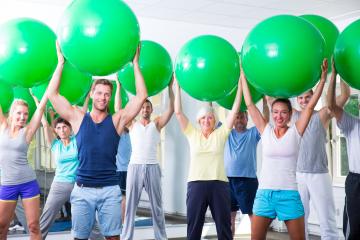 A diverse fitness group in a gym holding green exercise balls over their heads, smiling and engaging in a fun and energetic workout session promoting health and well-being
 : Stock Photo or Stock Video Download rcfotostock photos, images and assets rcfotostock | RC Photo Stock.: