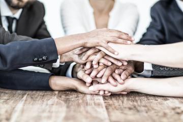 A diverse group of hands stacked together over a wooden table, symbolizing teamwork, unity, collaboration, and solidarity in a professional or community setting
 : Stock Photo or Stock Video Download rcfotostock photos, images and assets rcfotostock | RC Photo Stock.: