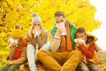 A family of four sitting under golden autumn trees, using tissues to wipe their noses, symbolizing seasonal allergies, colds, or flu during the fall season, dressed in warm autumn clothing : Stock Photo or Stock Video Download rcfotostock photos, images and assets rcfotostock | RC Photo Stock.: