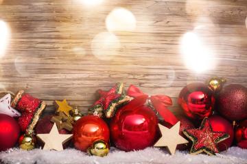 A festive arrangement of red and gold Christmas ornaments, stars, and decorations set on snowy ground against a wooden background, illuminated with soft, warm light and holiday sparkle. : Stock Photo or Stock Video Download rcfotostock photos, images and assets rcfotostock | RC Photo Stock.: