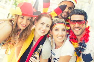 A group of friends celebrating with German flag-themed accessories, smiling and enjoying the festive atmosphere, dressed in colorful outfits, showing excitement and unity : Stock Photo or Stock Video Download rcfotostock photos, images and assets rcfotostock | RC Photo Stock.: