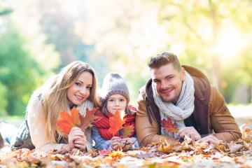 A happy family of three lying on colorful autumn leaves in a sunny park, holding vibrant red and orange leaves, dressed warmly with scarves and hats, enjoying quality time together in nature
 : Stock Photo or Stock Video Download rcfotostock photos, images and assets rcfotostock | RC Photo Stock.: