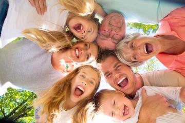 A happy multigenerational family forming a circle outdoors, laughing and smiling, capturing a joyful moment together under a sunny sky with vibrant greenery in the background : Stock Photo or Stock Video Download rcfotostock photos, images and assets rcfotostock | RC Photo Stock.: