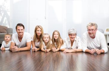 A happy multi-generational family lying on the floor together, smiling and enjoying a moment of togetherness in a bright modern living room- Stock Photo or Stock Video of rcfotostock | RC Photo Stock