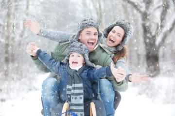 A joyful family sledding in a snowy winter forest, wearing warm hats and jackets, laughing and celebrating together, surrounded by falling snowflakes in a magical outdoor setting : Stock Photo or Stock Video Download rcfotostock photos, images and assets rcfotostock | RC Photo Stock.: