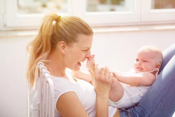 A joyful mother playing with her baby indoors, holding the baby's feet and laughing, bathed in warm sunlight from a nearby window, showcasing love, bonding, and maternal happiness
 : Stock Photo or Stock Video Download rcfotostock photos, images and assets rcfotostock | RC Photo Stock.: