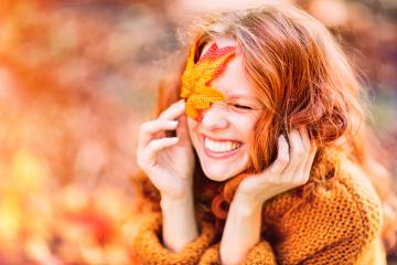 A joyful red-haired woman in an autumn setting, smiling with a vibrant orange leaf covering one eye, wearing a cozy sweater and surrounded by warm fall tones and sunlight
 : Stock Photo or Stock Video Download rcfotostock photos, images and assets rcfotostock | RC Photo Stock.: