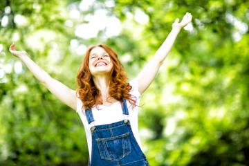 A joyful red-haired woman in denim overalls with arms raised, smiling brightly in a lush green outdoor setting, celebrating happiness and freedom in nature
 : Stock Photo or Stock Video Download rcfotostock photos, images and assets rcfotostock | RC Photo Stock.: