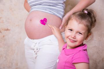 A little girl paints a pink heart on her pregnant mother : Stock Photo or Stock Video Download rcfotostock photos, images and assets rcfotostock | RC Photo Stock.: