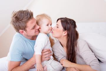 A loving family moment with a mother kissing her toddler, the father holding the child close, all sharing a warm, happy interaction in a cozy home environment filled with affection.
- Stock Photo or Stock Video of rcfotostock | RC Photo Stock