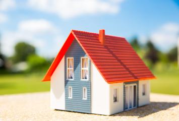 A miniature house with a red roof and blue walls sits on a sunny outdoor surface, symbolizing real estate, home ownership, and cozy living in a bright, natural environment : Stock Photo or Stock Video Download rcfotostock photos, images and assets rcfotostock | RC Photo Stock.: