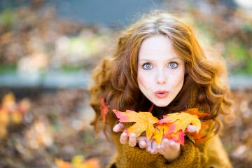 A red-haired woman in an autumn setting, holding colorful fall leaves in her hands, blowing them playfully, surrounded by warm tones and a blurred natural background : Stock Photo or Stock Video Download rcfotostock photos, images and assets rcfotostock | RC Photo Stock.: