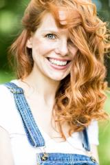 A red-haired woman with curly hair and a bright smile wearing denim overalls, captured outdoors with a lush green background, radiating natural beauty and joy
 : Stock Photo or Stock Video Download rcfotostock photos, images and assets rcfotostock | RC Photo Stock.: