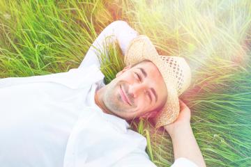 A relaxed man lying on green grass wearing a straw hat and a white shirt, smiling happily under a bright sunny sky, enjoying leisure and tranquility in a natural outdoor setting : Stock Photo or Stock Video Download rcfotostock photos, images and assets rcfotostock | RC Photo Stock.: