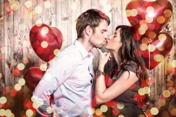 A romantic couple kissing with red heart-shaped balloons in a festive background featuring wooden planks and golden bokeh lights : Stock Photo or Stock Video Download rcfotostock photos, images and assets rcfotostock | RC Photo Stock.:
