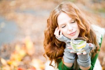 A serene woman with red hair, closed eyes, and a peaceful smile holding a cup of lemon mint tea, sitting outdoors in autumn with colorful leaves in the background, enjoying a cozy moment
- Stock Photo or Stock Video of rcfotostock | RC Photo Stock