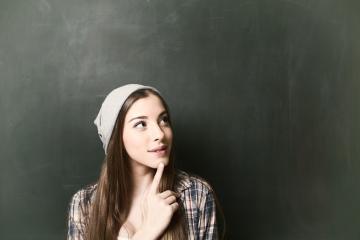 A thoughtful young woman with long hair wearing a gray beanie and plaid shirt, looking upwards against a green chalkboard background, symbolizing creativity, curiosity, and inspiration : Stock Photo or Stock Video Download rcfotostock photos, images and assets rcfotostock | RC Photo Stock.: