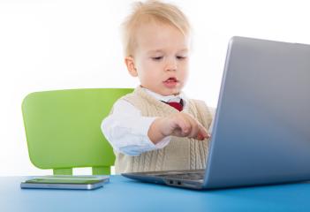 A young toddler sits at a desk, typing on a laptop with a focused expression, wearing a formal outfit, against a bright background, combining technology and play in a charming scene. : Stock Photo or Stock Video Download rcfotostock photos, images and assets rcfotostock | RC Photo Stock.: