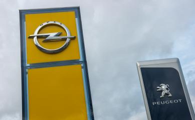 AACHEN, GERMANY FEBRUARY, 2017: Peugeot and Opel dealership sign against cloudy sky. Peugeot is a French automobile manufacturer and part of Groupe PSA. Opel AG is a German automobile manufacturer.- Stock Photo or Stock Video of rcfotostock | RC Photo Stock