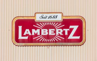 AACHEN, GERMANY OCTOBER, 2017: Lambertz Logo on a factory building. The Lambertz Group is a Aachener Printen- and chocolate factory founded by Henry Lambertz 1688 and a manufacturer Christmas cookies. : Stock Photo or Stock Video Download rcfotostock photos, images and assets rcfotostock | RC-Photo-Stock.: