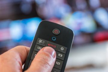 AACHEN, GERMANY OCTOBER, 2017:Man holds a remote control and push a Netflix button. Netflix Inc. is an American company founded specializes in and provides streaming media and video on demand online.- Stock Photo or Stock Video of rcfotostock | RC Photo Stock