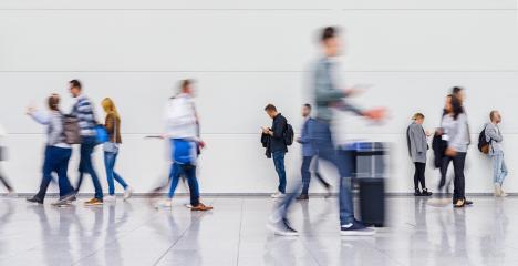 Anonymous blurred crowd of business people walks by gear on a trade fair or in an airport- Stock Photo or Stock Video of rcfotostock | RC Photo Stock