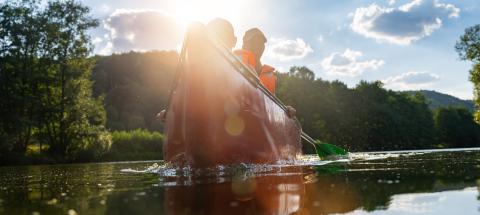 Back view of three people in a canoe paddling on a river, highlighted by warm sunlight and lens flare at a river in germany. Family on kayak ride. Wild nature and water fun on summer vacation.- Stock Photo or Stock Video of rcfotostock | RC Photo Stock