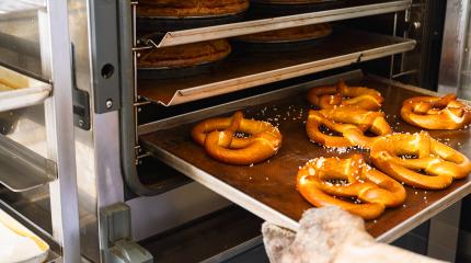 Baker getting fresh bavarian pretzels out of oven on baking sheet from the bakery : Stock Photo or Stock Video Download rcfotostock photos, images and assets rcfotostock | RC Photo Stock.: