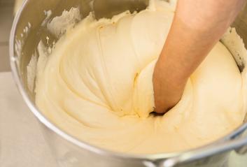 Baker hand mixes thick cake batter in a large stainless steel bowl, showcasing the texture and consistency of the batter during the baking process in a professional kitchen setting : Stock Photo or Stock Video Download rcfotostock photos, images and assets rcfotostock | RC Photo Stock.: