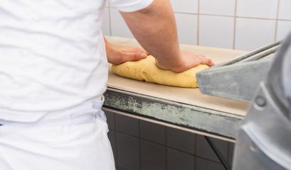 Baker kneading cookie dough on a work surface in a bakery, preparing the dough for rolling or cutting in a professional baking environment with visible equipment in the background : Stock Photo or Stock Video Download rcfotostock photos, images and assets rcfotostock | RC Photo Stock.:
