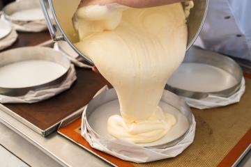 Baker pouring cake batter into a round baking pan in a bakery, preparing the batter for baking in a professional baking environment : Stock Photo or Stock Video Download rcfotostock photos, images and assets rcfotostock | RC Photo Stock.:
