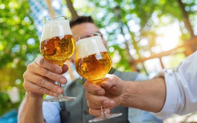 Bavarian friends man clinking beer mugs with traditional Bavarian cuisine in a beer garden or oktoberfest- Stock Photo or Stock Video of rcfotostock | RC Photo Stock