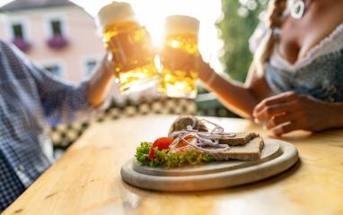 Bavarian Obatzda with pretzels and radishes and beer mugs, man and young woman in tracht in the background at beer garden or oktoberfest, Munich, Germany : Stock Photo or Stock Video Download rcfotostock photos, images and assets rcfotostock | RC Photo Stock.: