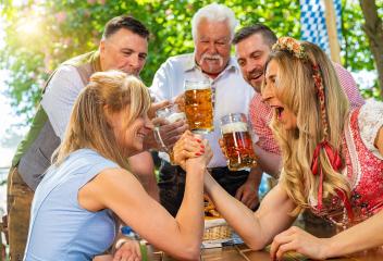 Bavarian women practicing the high art of arm wrestling with friends that cheer on in a beer garden or oktoberfest- Stock Photo or Stock Video of rcfotostock | RC Photo Stock