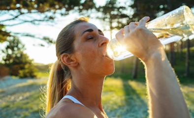 Beautiful girl in sportswear drinks water from a bottle at morning on the beach- Stock Photo or Stock Video of rcfotostock | RC Photo Stock