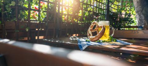 Beer mug with fresh pretzel or brezen and hops and sitting benches at  Oktoberfest, Munich, Germany, banner size- Stock Photo or Stock Video of rcfotostock | RC Photo Stock