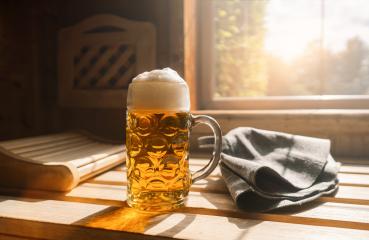 Beer mug with frothy beer rest on a ledge in a sauna, catching sunlight. Nearby finnish Sauna hats on a wooden bench. spa and wellness concept image- Stock Photo or Stock Video of rcfotostock | RC Photo Stock