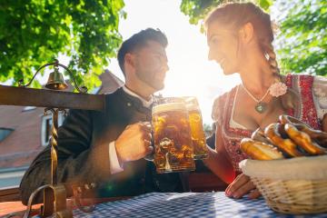 Best friends in Bavarian Tracht sitting in Beer garden or oktoberfest and enjoying a glass of beer and the sun- Stock Photo or Stock Video of rcfotostock | RC Photo Stock
