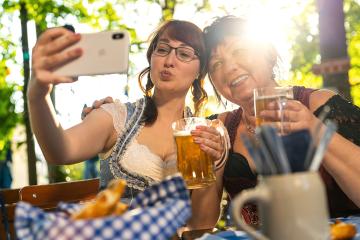 Best friends mother and daughter in Bavarian Tracht making a Selfie with the phone, with mugs of beer in Bavarian beer garden or oktoberfest : Stock Photo or Stock Video Download rcfotostock photos, images and assets rcfotostock | RC Photo Stock.: