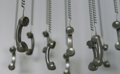 black telephone receivers hanging over gray background concept hold or contact us - Stock Photo or Stock Video of rcfotostock | RC Photo Stock