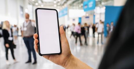 Businesswoman hand holding black cellphone with white screen at a trade fair, copyspace for your individual text.- Stock Photo or Stock Video of rcfotostock | RC-Photo-Stock