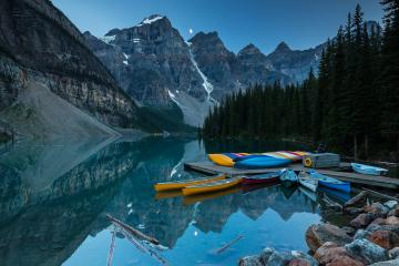 Canoes on a jetty at Moraine lake, Banff national park in the Rocky Mountains at night with moon, Alberta, Canada- Stock Photo or Stock Video of rcfotostock | RC Photo Stock