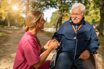 caregiver in pink kneels beside a smiling elderly man in a wheelchair in a sunny autumn park. Dementia retirement home concept image : Stock Photo or Stock Video Download rcfotostock photos, images and assets rcfotostock | RC Photo Stock.: