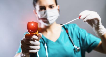 Checking the temperature with a laser thermometer by a person in a protective suit, protective mask and smear tube test. Thermometer (thermometer gun) held in hands wearing disposable gloves.- Stock Photo or Stock Video of rcfotostock | RC-Photo-Stock