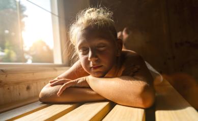 Child resting on a sauna bench, sunlight filtering through a window, eyes closed : Stock Photo or Stock Video Download rcfotostock photos, images and assets rcfotostock | RC Photo Stock.: