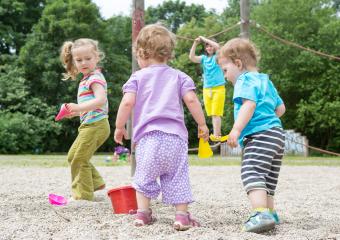 Children playing outdoors in a sandbox, holding toy buckets and shovels, with a child climbing in the background, surrounded by green trees and a summer playground setting
 : Stock Photo or Stock Video Download rcfotostock photos, images and assets rcfotostock | RC Photo Stock.: