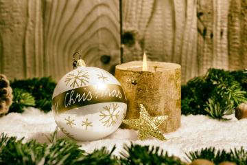 Christmas-themed setup with a white ornament featuring gold snowflakes and text, a lit rustic candle, glittery golden star, pine branches, and snow on a wooden background : Stock Photo or Stock Video Download rcfotostock photos, images and assets rcfotostock | RC Photo Stock.: