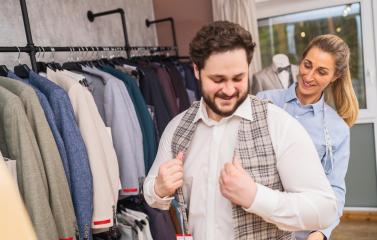 Client trying on a checkered jacket with tailor assisting in a boutique- Stock Photo or Stock Video of rcfotostock | RC Photo Stock